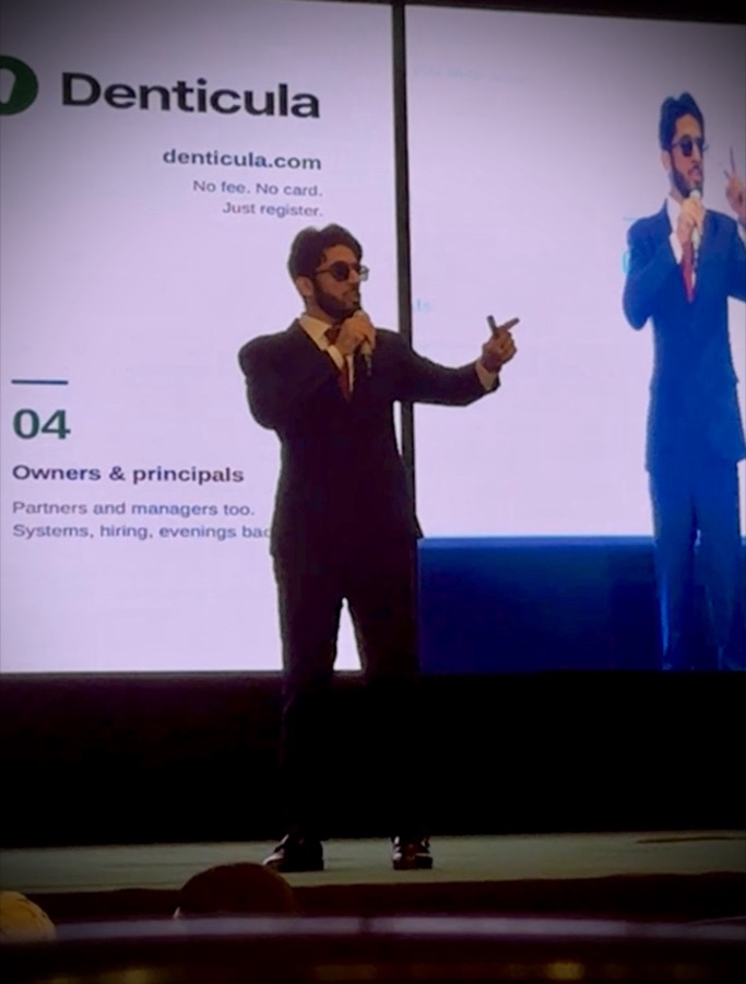 Moiz Khurram speaking on stage at a dental industry conference for Denticula